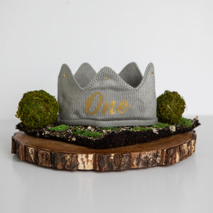 Gray knitted crown with One in gold lettering and gold accents