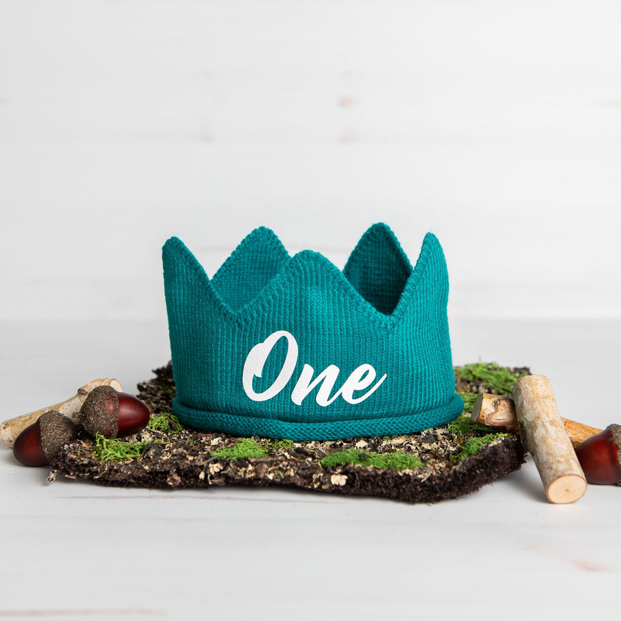 Teal knitted crown with One in white lettering