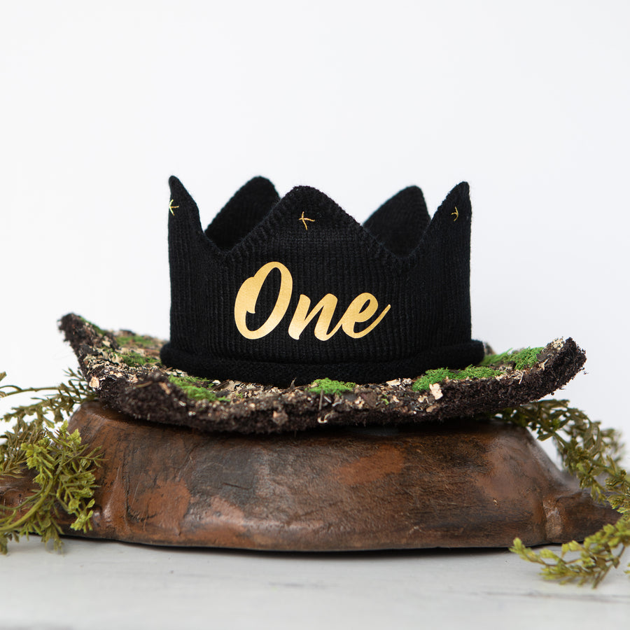 Black knitted crown with One in gold lettering and gold accents