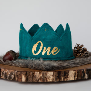 Teal knitted crown with One in gold lettering and gold accents