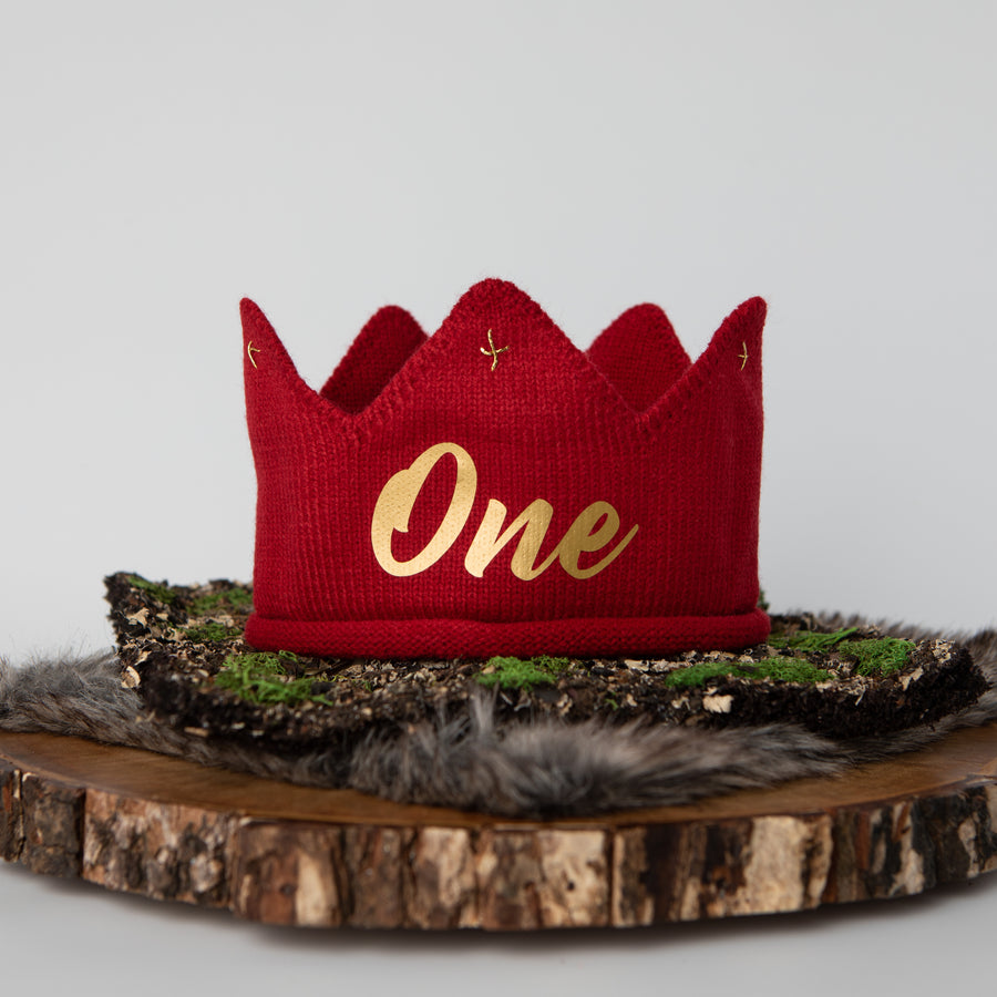 Red knitted crown with One in gold lettering and gold accents